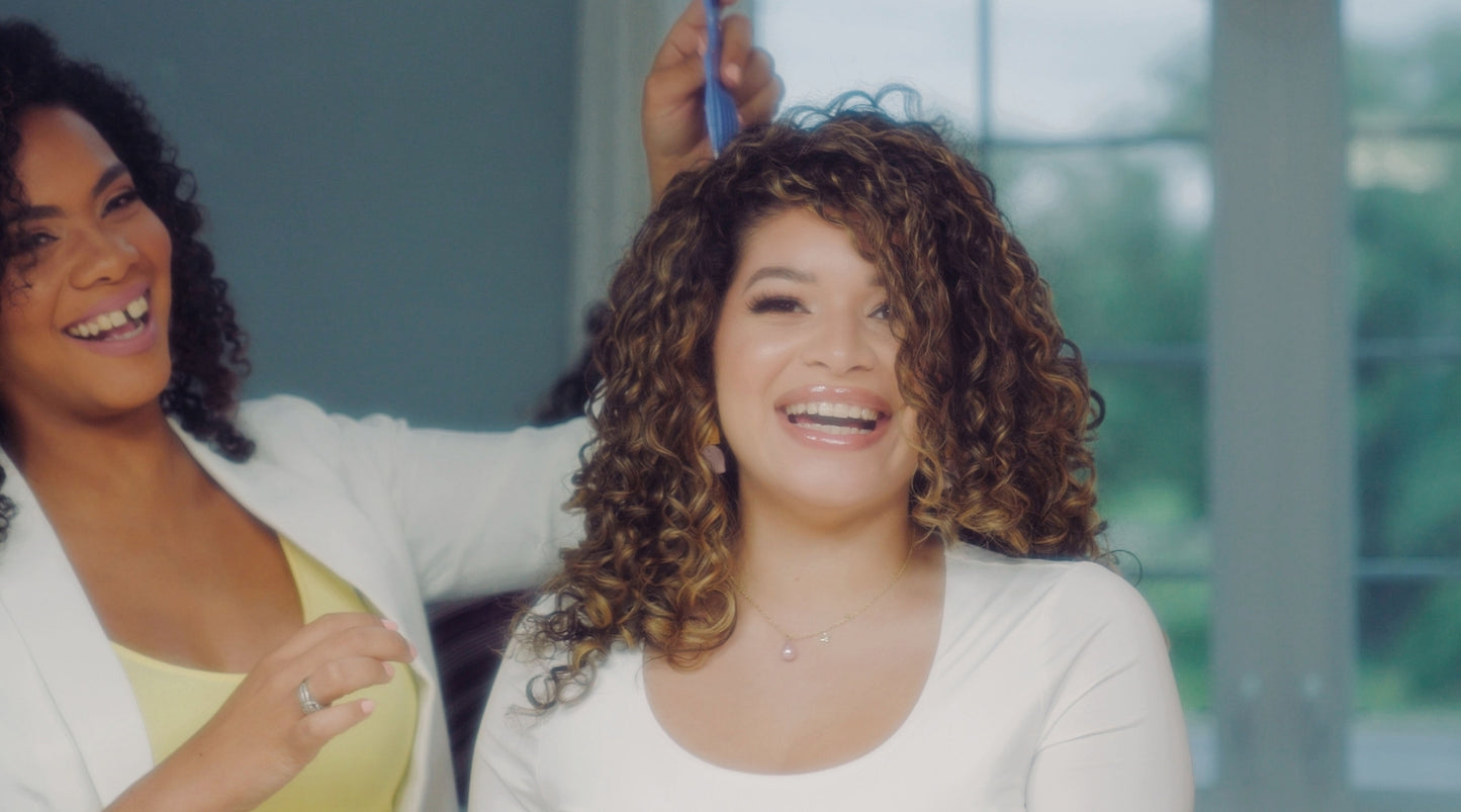 two curly women smiling