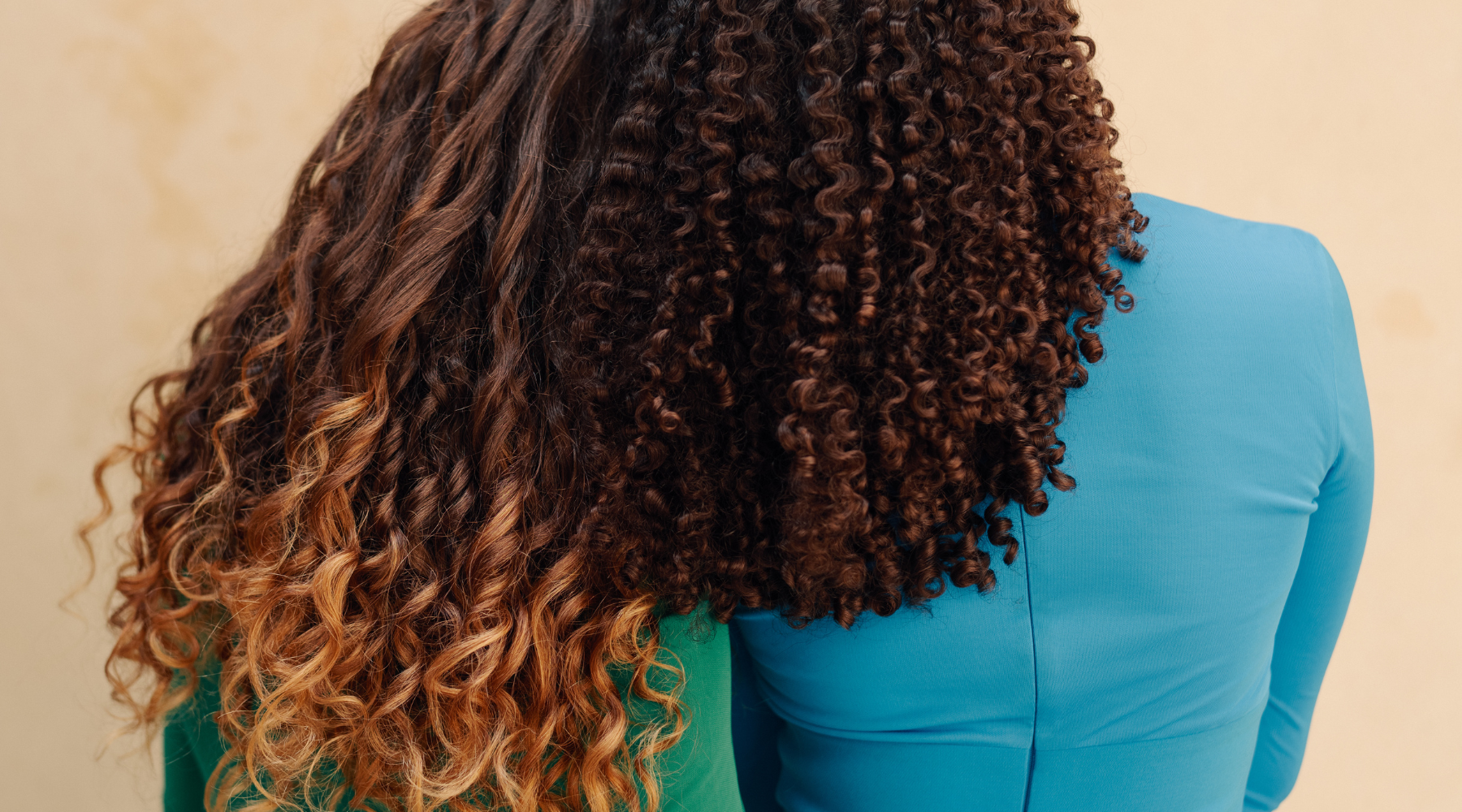 OCOA: Curly women embracing each other from the back